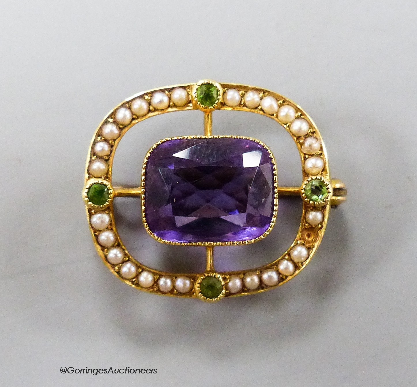 An early 20th century 15ct, amethyst, garnet and seed pearl pendant brooch, in the suffragette colours, 21mm, gross 3.6 grams.